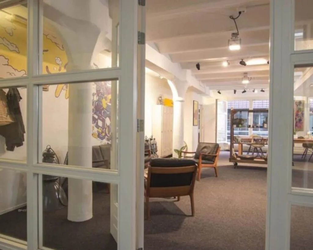 Moderne en creatieve kantoorruimte aan de Korte Leidsedwarsstraat 12 in Amsterdam met loungehoek en kunst aan de muren.