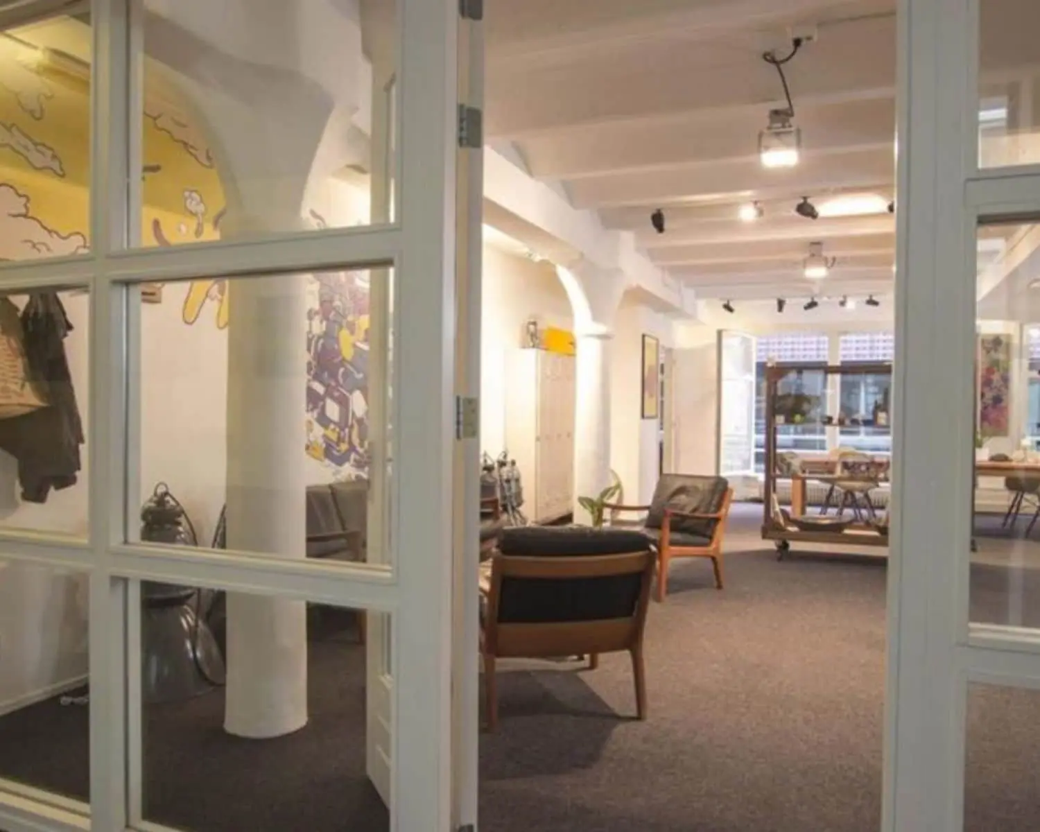 Moderne en creatieve kantoorruimte aan de Korte Leidsedwarsstraat 12 in Amsterdam met loungehoek en kunst aan de muren.