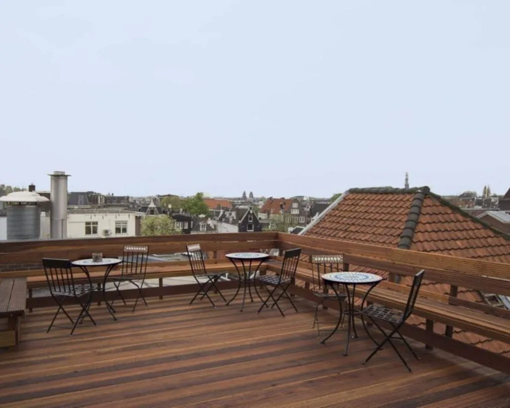 Houten dakterras met zitjes en uitzicht over de daken van Amsterdam bij Korte Leidsedwarsstraat 12.