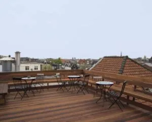 Houten dakterras met zitjes en uitzicht over de daken van Amsterdam bij Korte Leidsedwarsstraat 12.