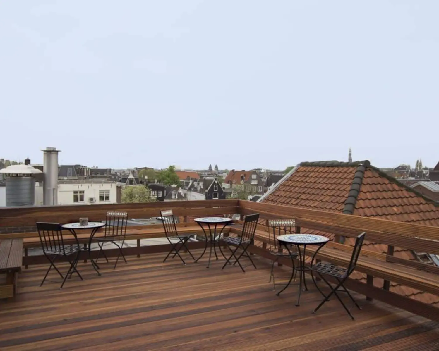 Houten dakterras met zitjes en uitzicht over de daken van Amsterdam bij Korte Leidsedwarsstraat 12.