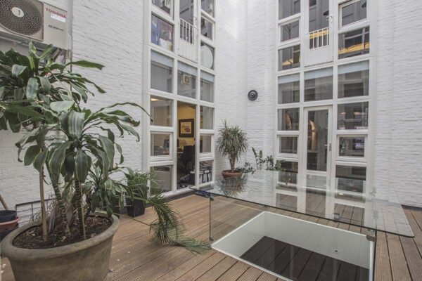 Moderne kantoorruimte met glazen dak en planten aan de Korte Leidsedwarsstraat in Amsterdam.