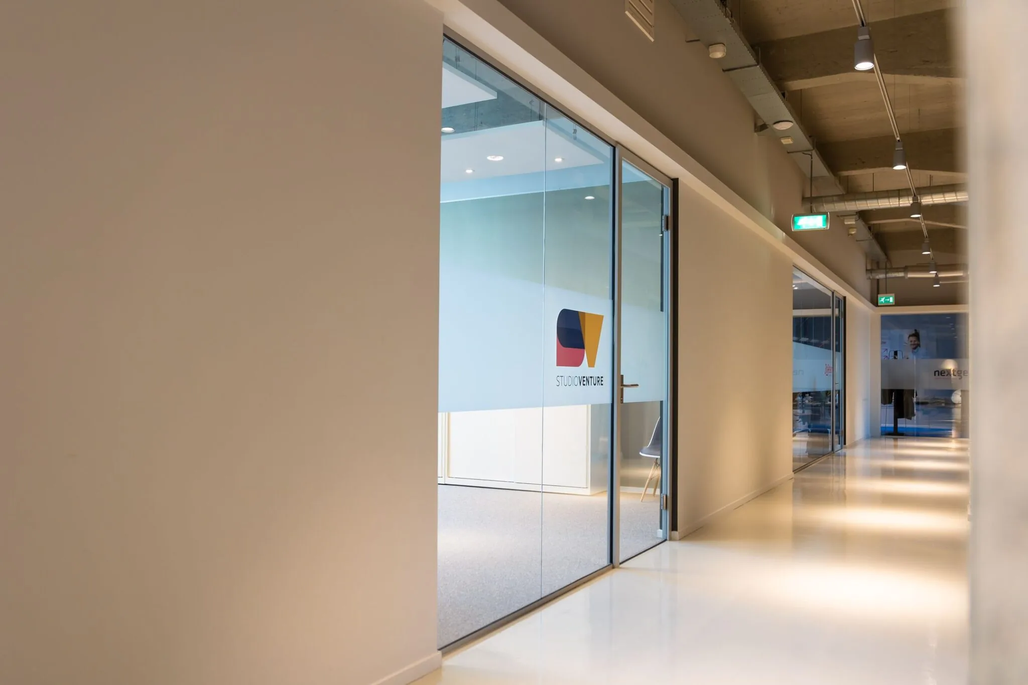 Moderne gang in de Lichttoren in Eindhoven met glazen kantoorruimte van Studio Venture.