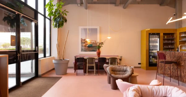 Stijlvol ingerichte lounge- en ontmoetingsruimte in de Lichttoren in Eindhoven met zithoek, vergadertafel en koffiebar.