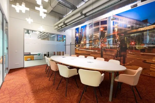 Moderne vergaderruimte in de Lichttoren in Eindhoven met ovale tafel, designstoelen en een grote wandfoto van het Stationsplein.