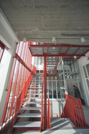 Rood metalen trappenhuis met glazen wanden in een modern kantoorgebouw aan de Panamalaan in Amsterdam.