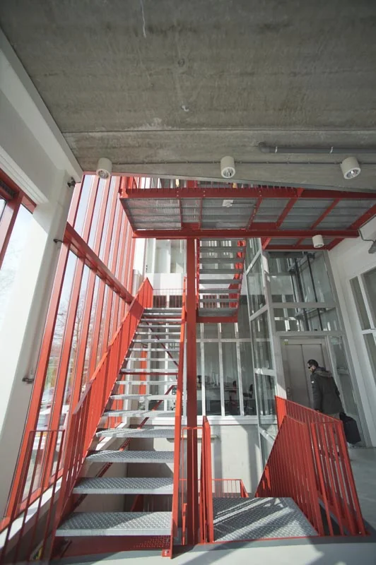 Rood metalen trappenhuis met glazen wanden in een modern kantoorgebouw aan de Panamalaan in Amsterdam.