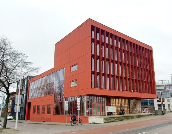 Modern rood kantoorgebouw aan de Panamalaan 1-8 in Amsterdam met grote verticale ramen.