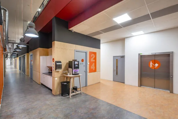 Moderne gang met koffiehoek en lift in een kantoorgebouw aan de Proostwetering 41 in Utrecht.