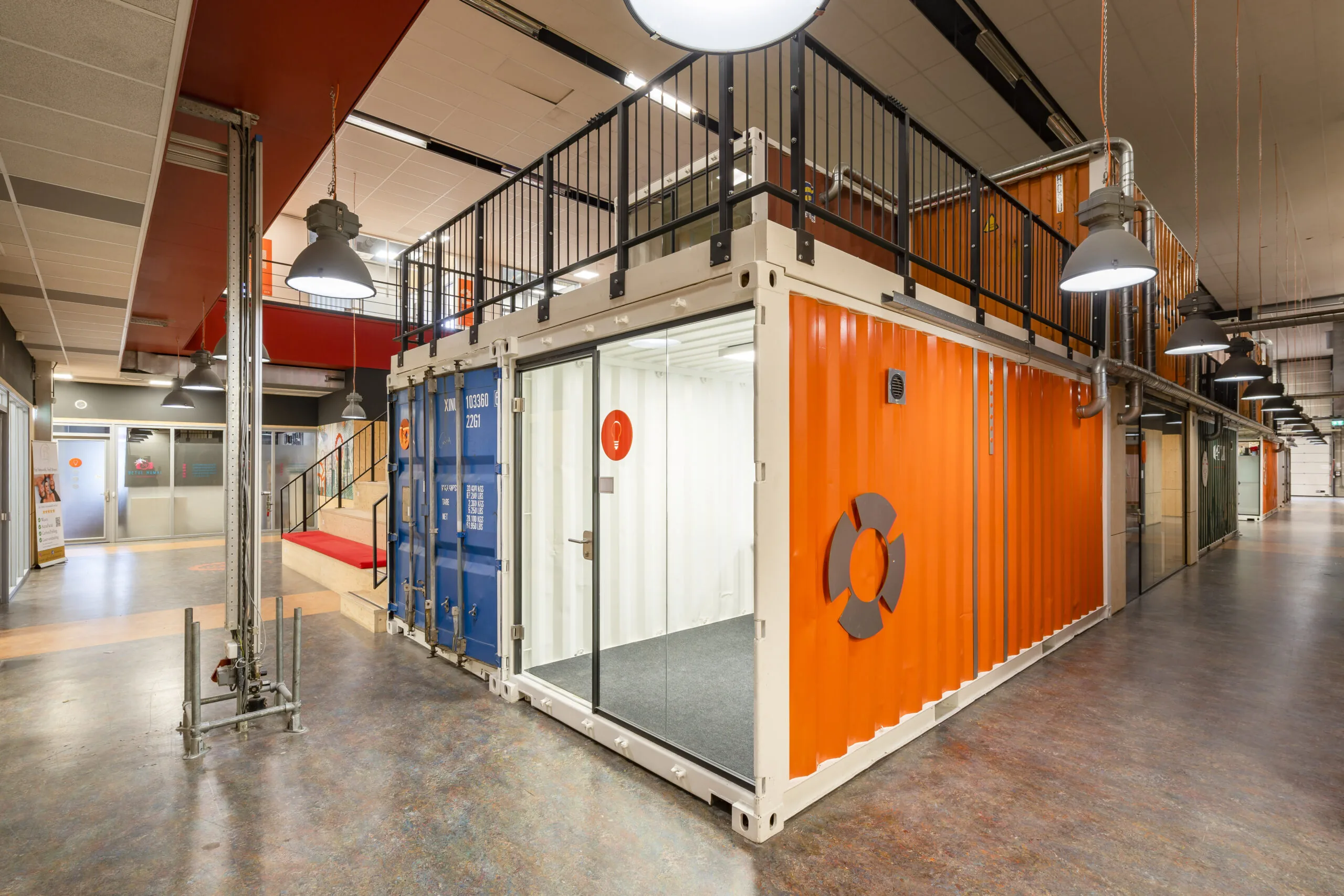 Moderne kantoorruimte in Utrecht ingericht met felgekleurde zeecontainers en industriële elementen.