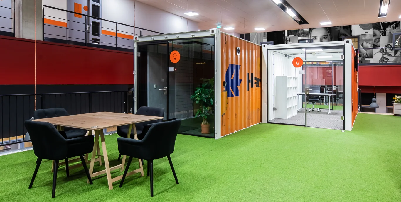 Moderne kantoorruimte in Utrecht met vergaderruimte in zeecontainers en kunstgrasvloer.