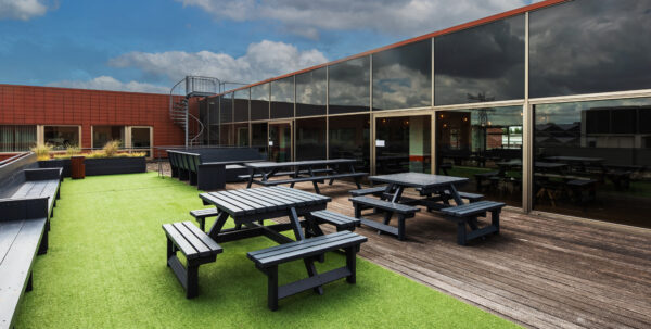 Dakterras met picknicktafels en kunstgras bij kantoorruimte aan de Proostwetering 41 in Utrecht.