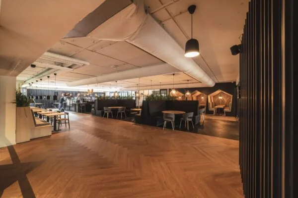 Moderne, sfeervol ingerichte kantoorruimte aan de Rietbaan 2-12 in Capelle aan den IJssel met zithoeken, houten vloer en stijlvolle verlichting.