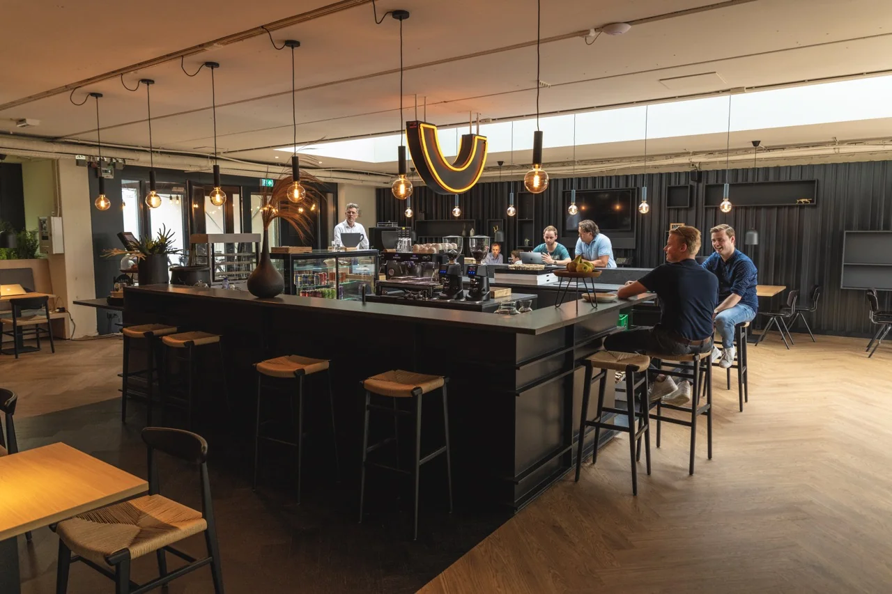 Moderne gezamenlijke kantoorruimte met bar en zithoeken aan de Rietbaan 2-12 in Capelle aan den IJssel.