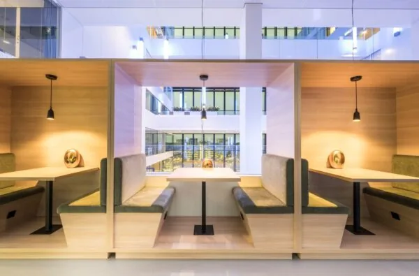 Moderne kantoorruimte met houten zitnissen en uitzicht op een licht atrium in Rijnzathe 12, De Meern.