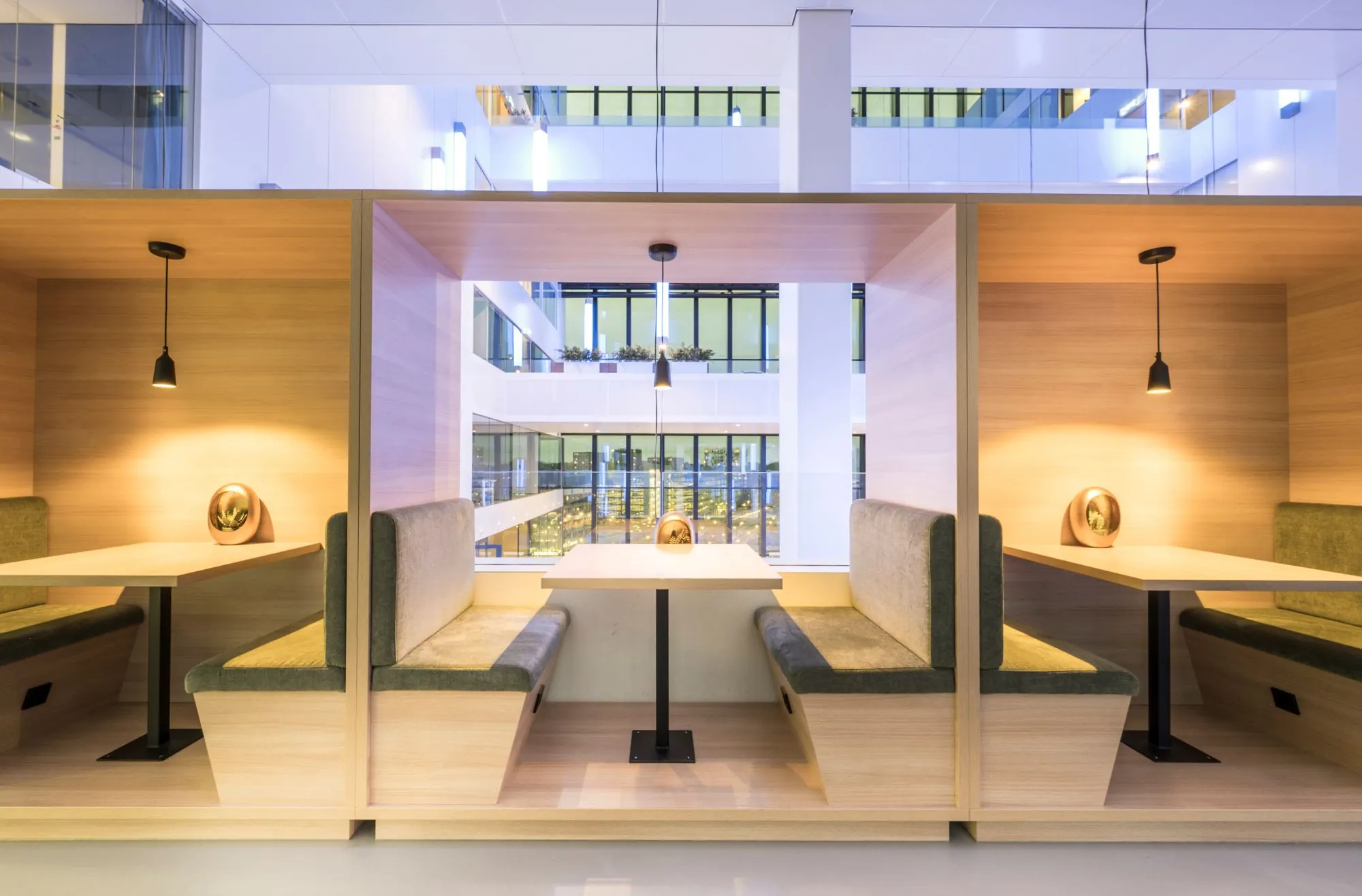 Moderne kantoorruimte met houten zitnissen en uitzicht op een licht atrium in Rijnzathe 12, De Meern.