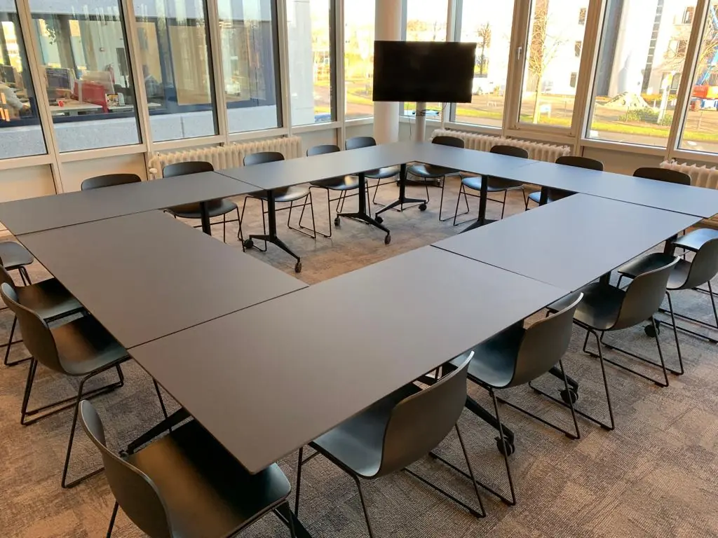 Vergaderruimte met U-vormige opstelling van tafels en stoelen bij Rijnzathe 6 in De Meern.