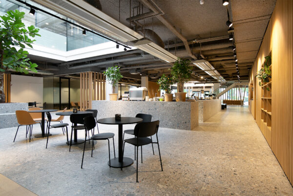 Moderne en open kantoorruimte aan de Rijnzathe 6 in De Meern met zitgelegenheid, grote planten en een koffiebar.