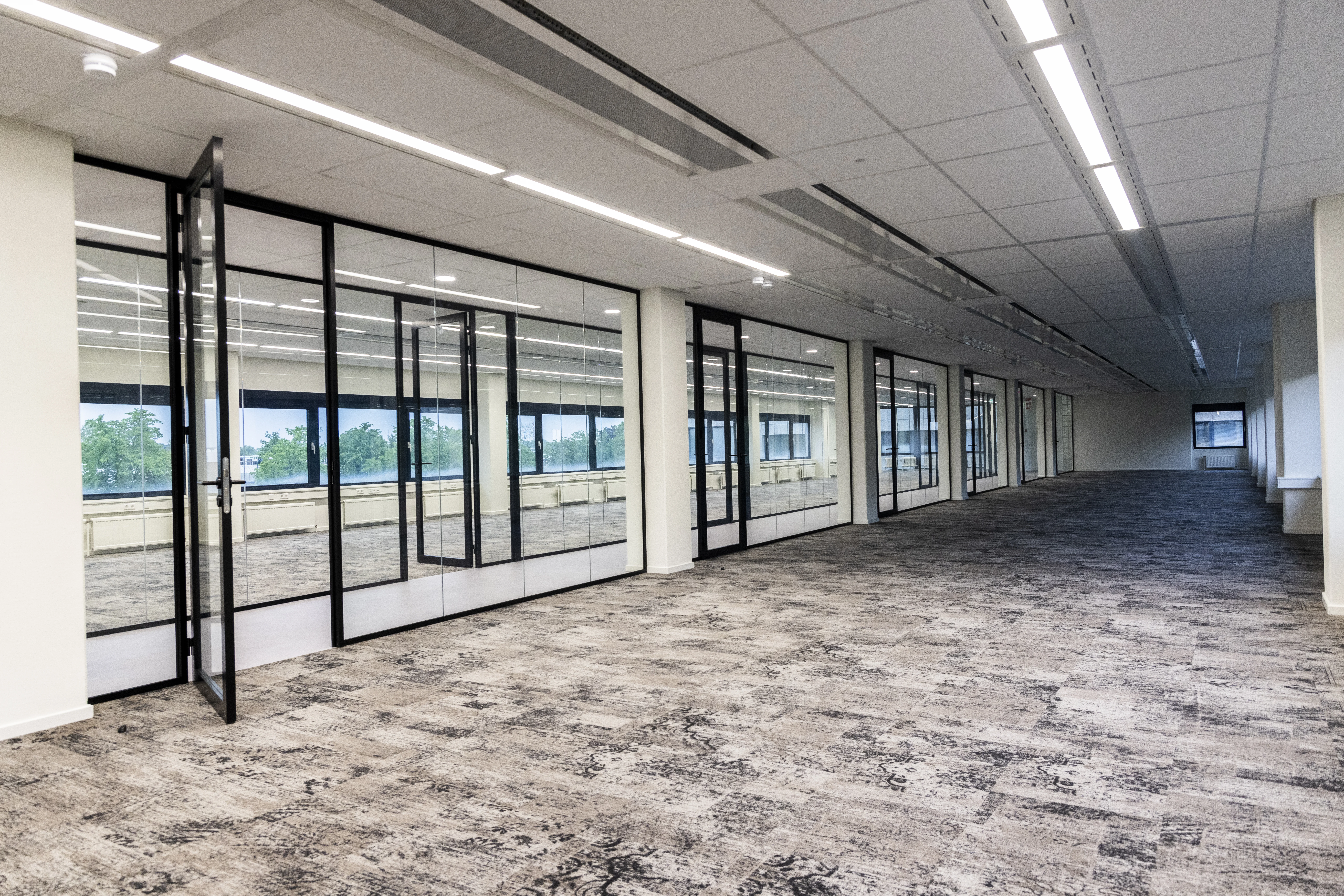 Modern office space for rent at Rijnzathe 6 in De Meern with glass partition walls and large windows.