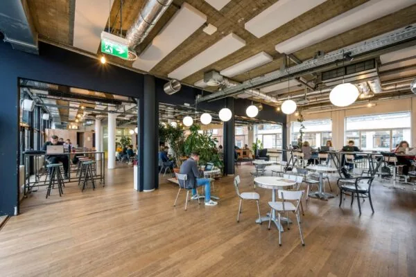 Moderne en open kantoorruimte aan de Singel 542 met flexwerkplekken, grote ramen en industriële inrichting.