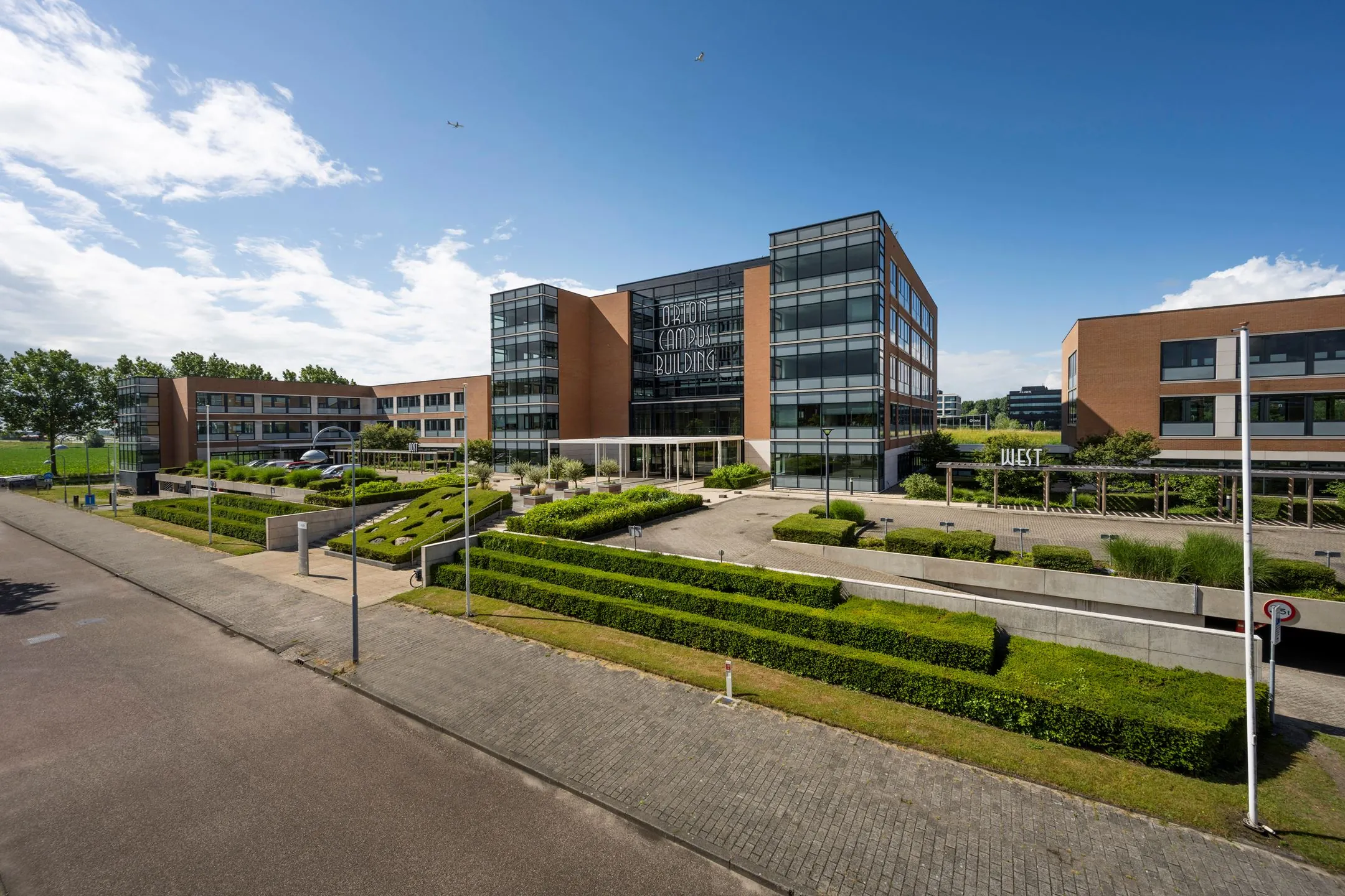 Modern kantoorgebouw aan de Siriusdreef 60 in Hoofddorp met opvallende glazen gevel en strakke landscaping.