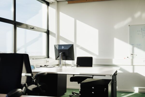Lichte, moderne kantoorruimte met bureaus, stoelen en een computerscherm aan de Sloterweg 303 in Badhoevedorp.