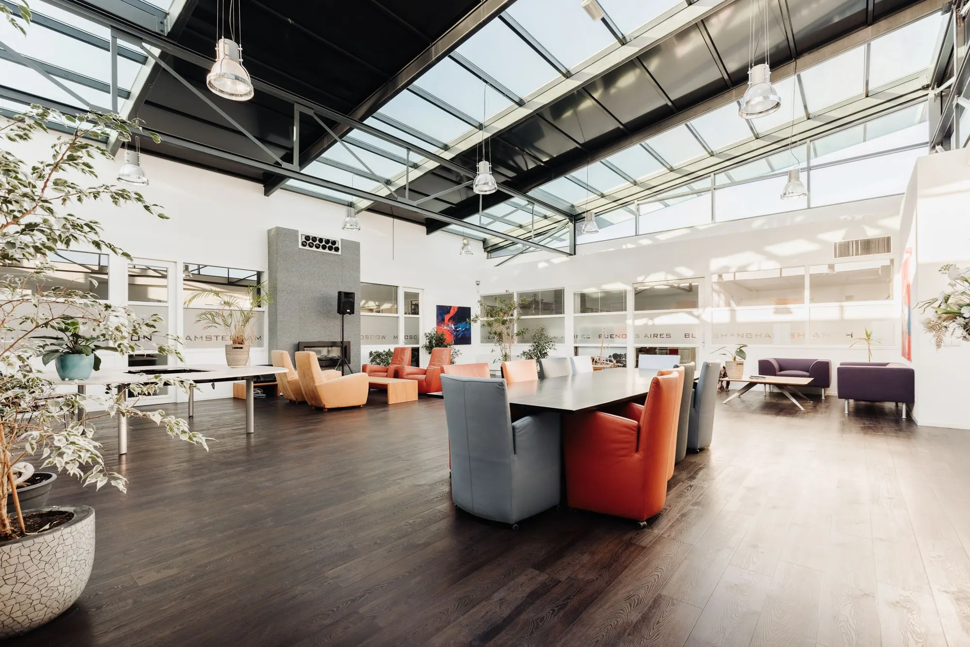 Moderne en lichte kantoorruimte aan de Sloterweg 303 in Badhoevedorp met hoge plafonds, grote ramen en kleurrijke zitplaatsen.