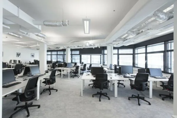 Moderne, lichte kantoorruimte met bureaus, bureaustoelen en computers in het pand aan de St. Jacobsstraat 123-135 in Utrecht.