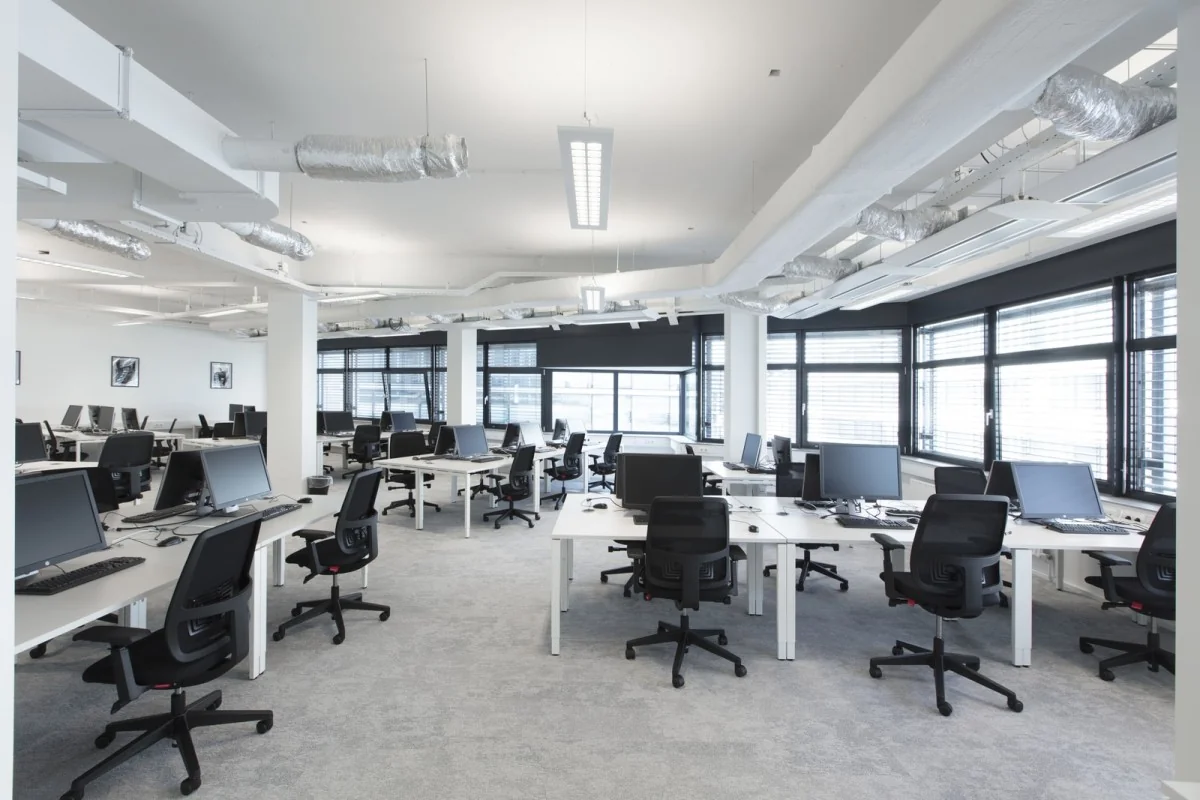 Moderne, lichte kantoorruimte met bureaus, bureaustoelen en computers in het pand aan de St. Jacobsstraat 123-135 in Utrecht.