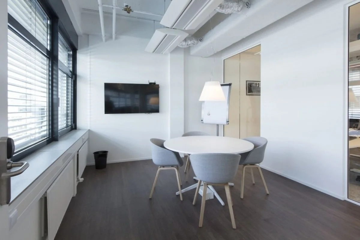 Moderne vergaderruimte met ronde tafel, vier stoelen en flatscreen in een kantoor aan de St. Jacobsstraat 123-135 in Utrecht.