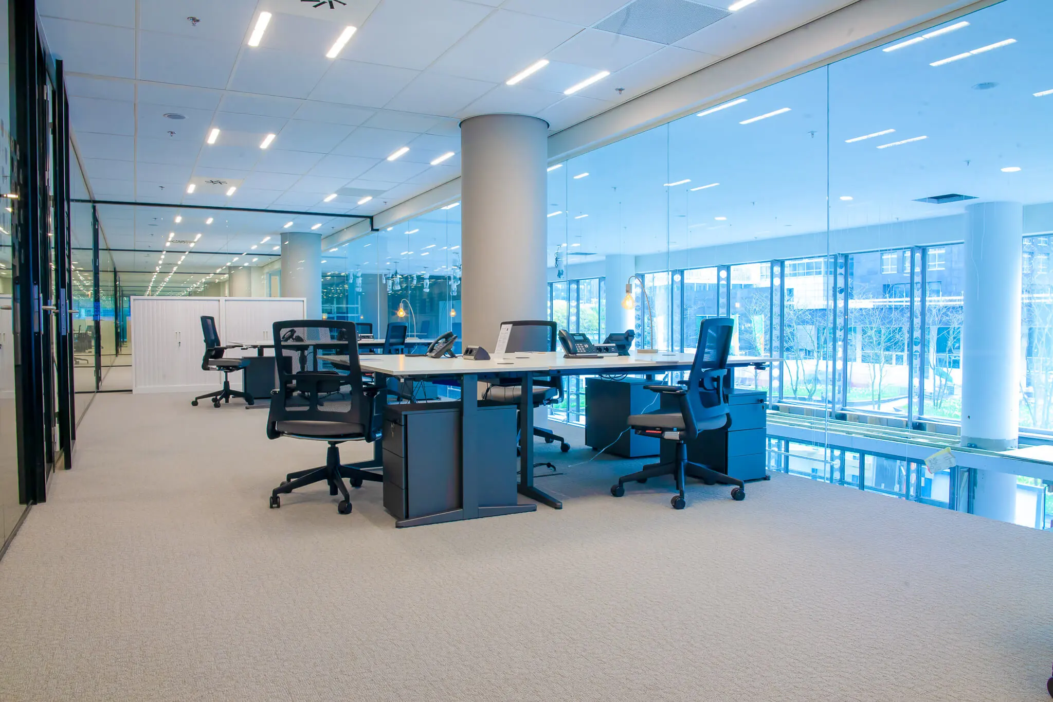 Moderne, ruime kantoorruimte te huur aan de Zuidas in Amsterdam met glazen wanden en ergonomische werkplekken.