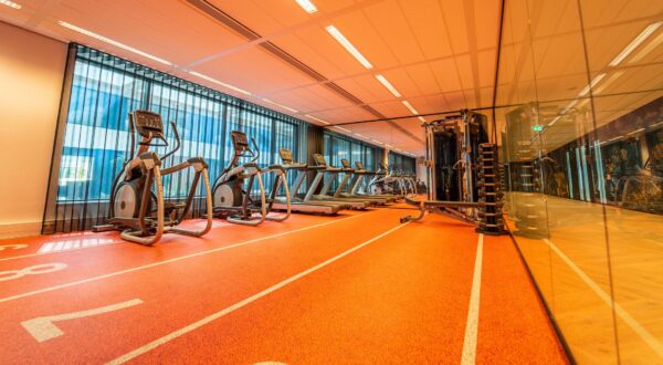 Moderne fitnessruimte met loopbanden, crosstrainers en krachtapparatuur aan de Lange Kleiweg 6-28.