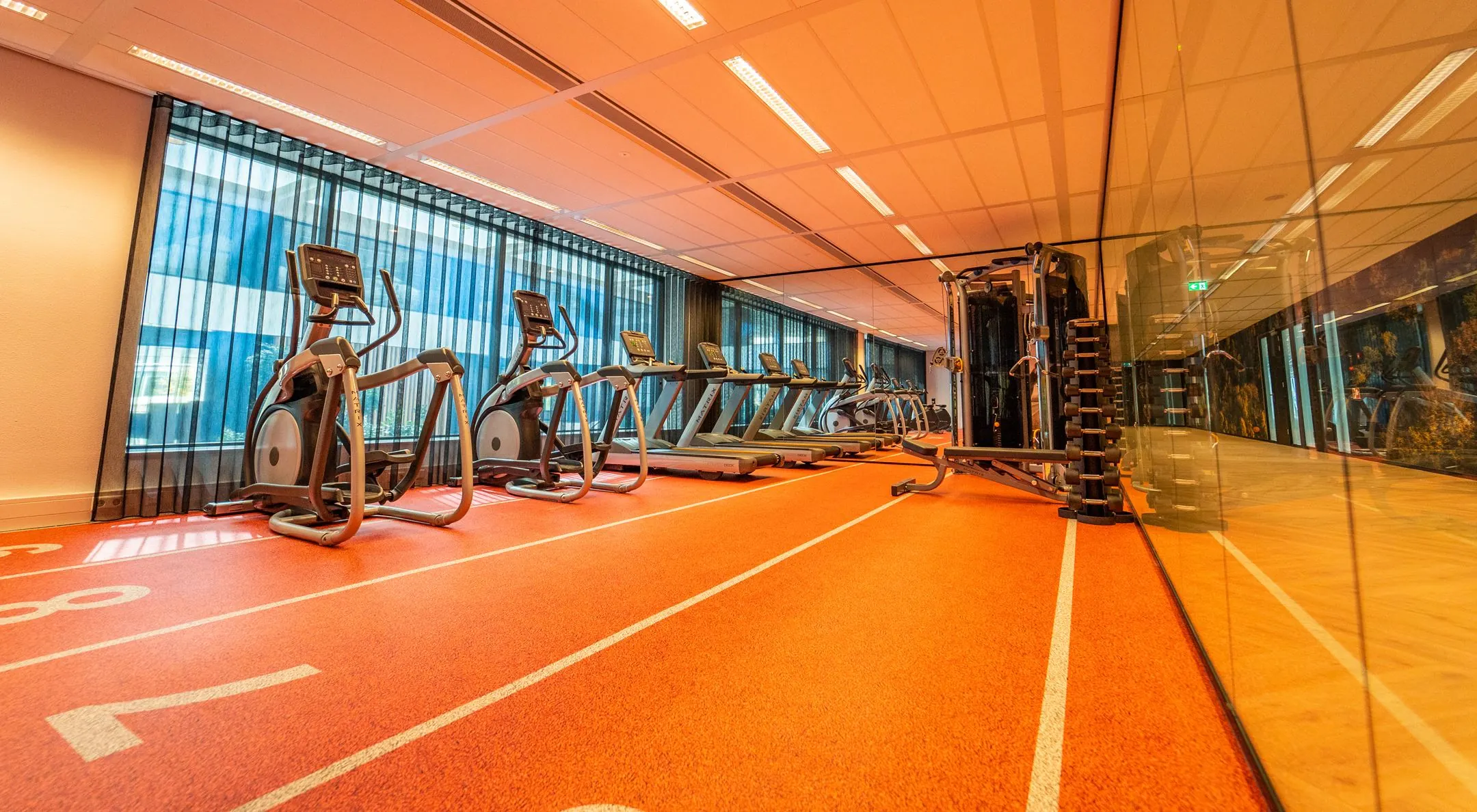 Moderne fitnessruimte met loopbanden, crosstrainers en krachtapparatuur aan de Lange Kleiweg 6-28.
