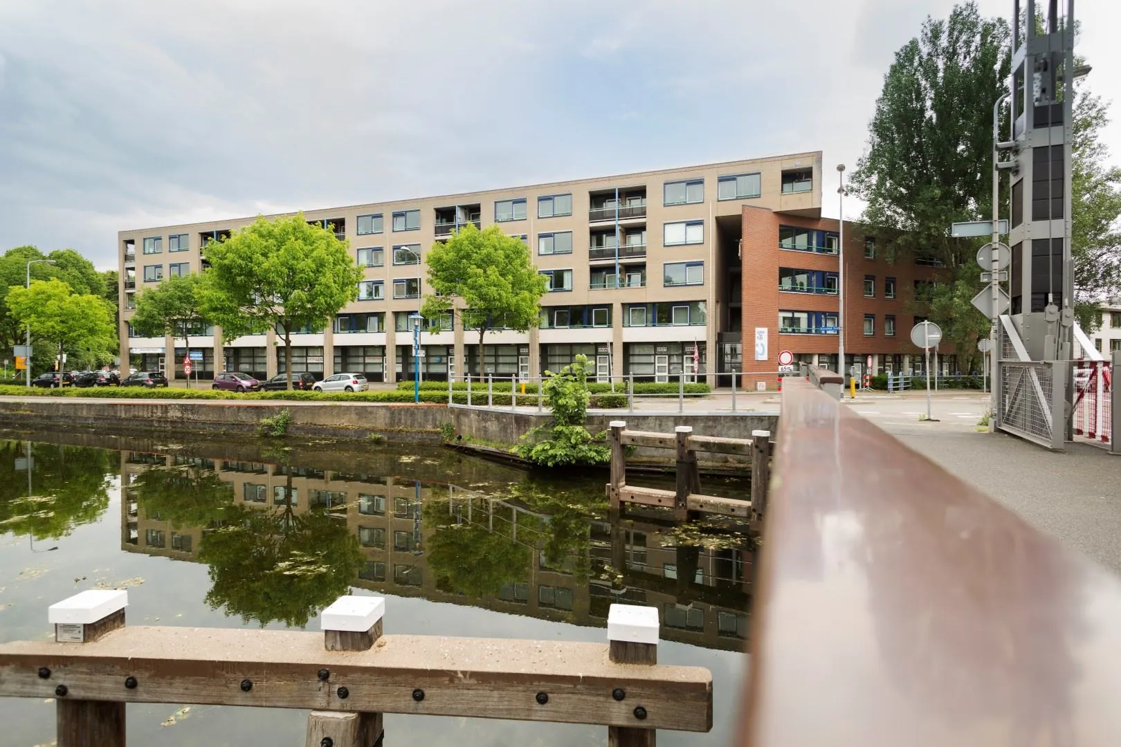Kantoorverzamelgebouw aan de Kanaaldijk-Zuid 19 met uitzicht op het kanaal en een brug op de voorgrond.
