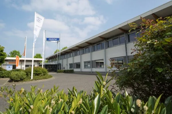 Vooraanzicht van het kantoorpand aan de Steenovenweg 5 met Place for Bizz vlaggen en entree.