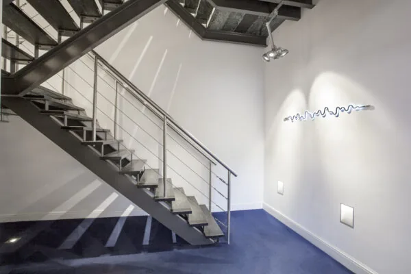 Moderne trap met metalen leuning in een strak afgewerkte kantoorruimte op Sweelinckplein 1-5.