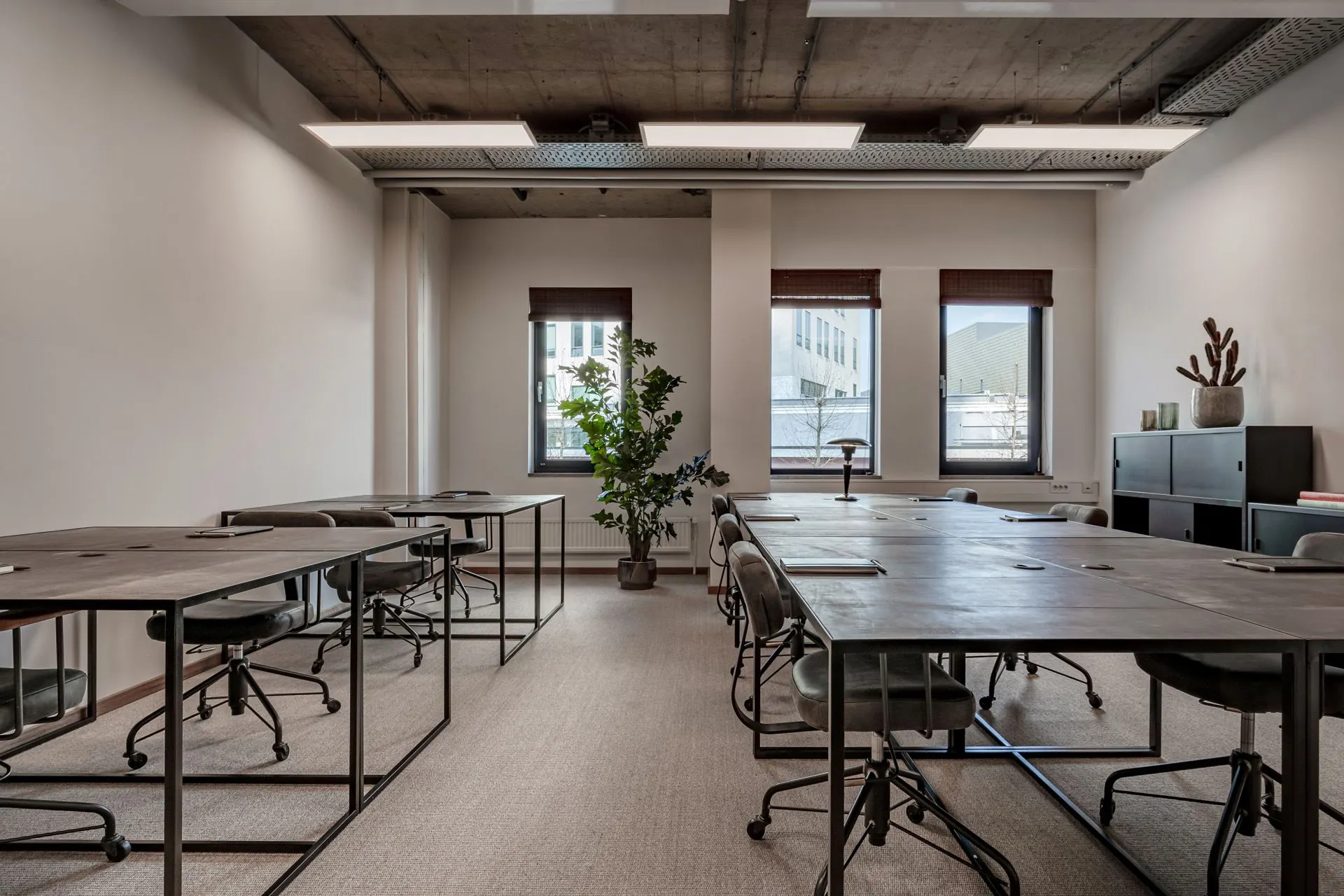 Moderne kantoorruimte aan de Emmasingel 33 met industriële stijl, grote ramen en meerdere werkplekken.