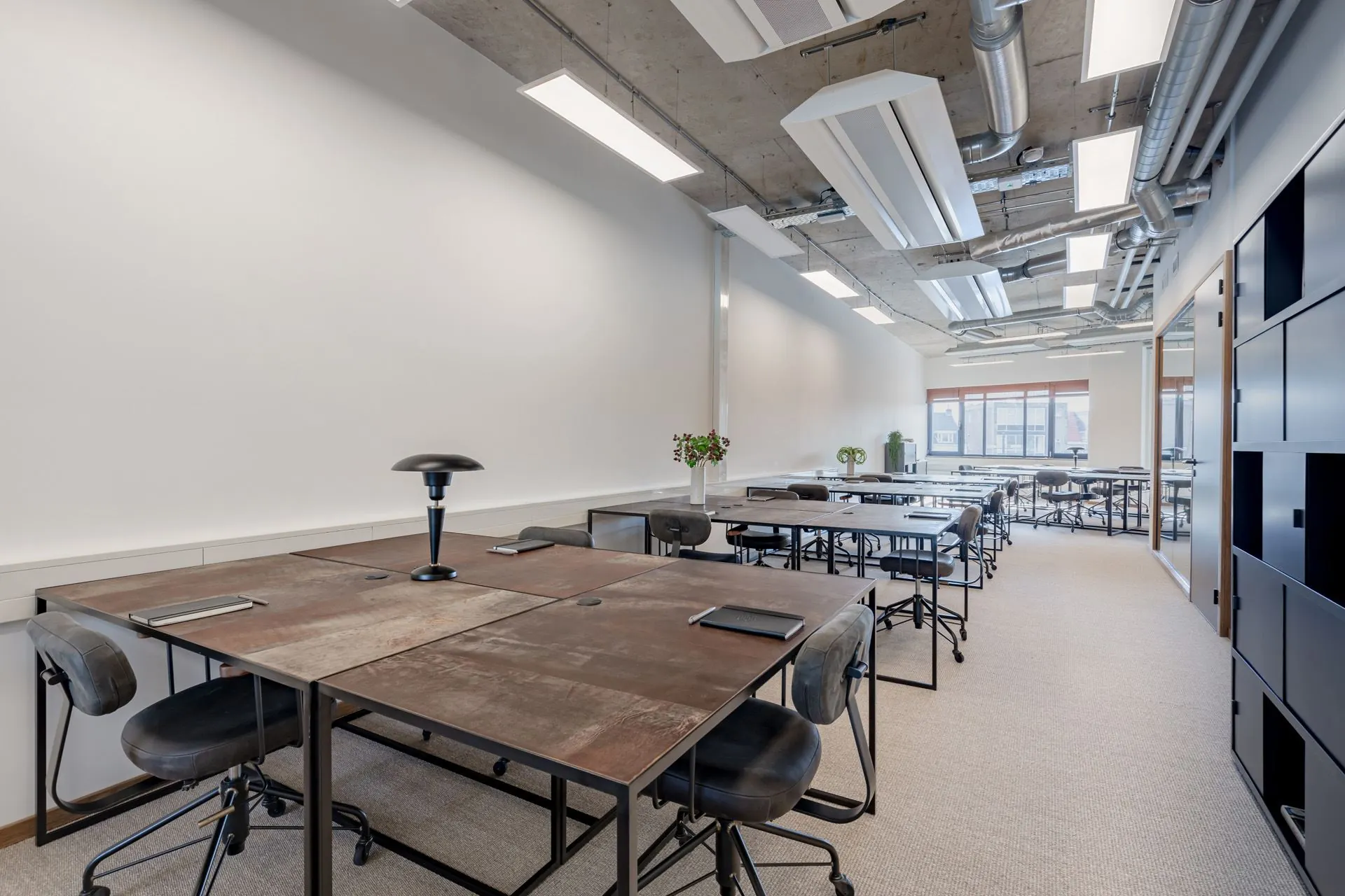 Moderne, lichte kantoorruimte aan de Emmasingel 33 met meerdere werkplekken en industriële afwerking.