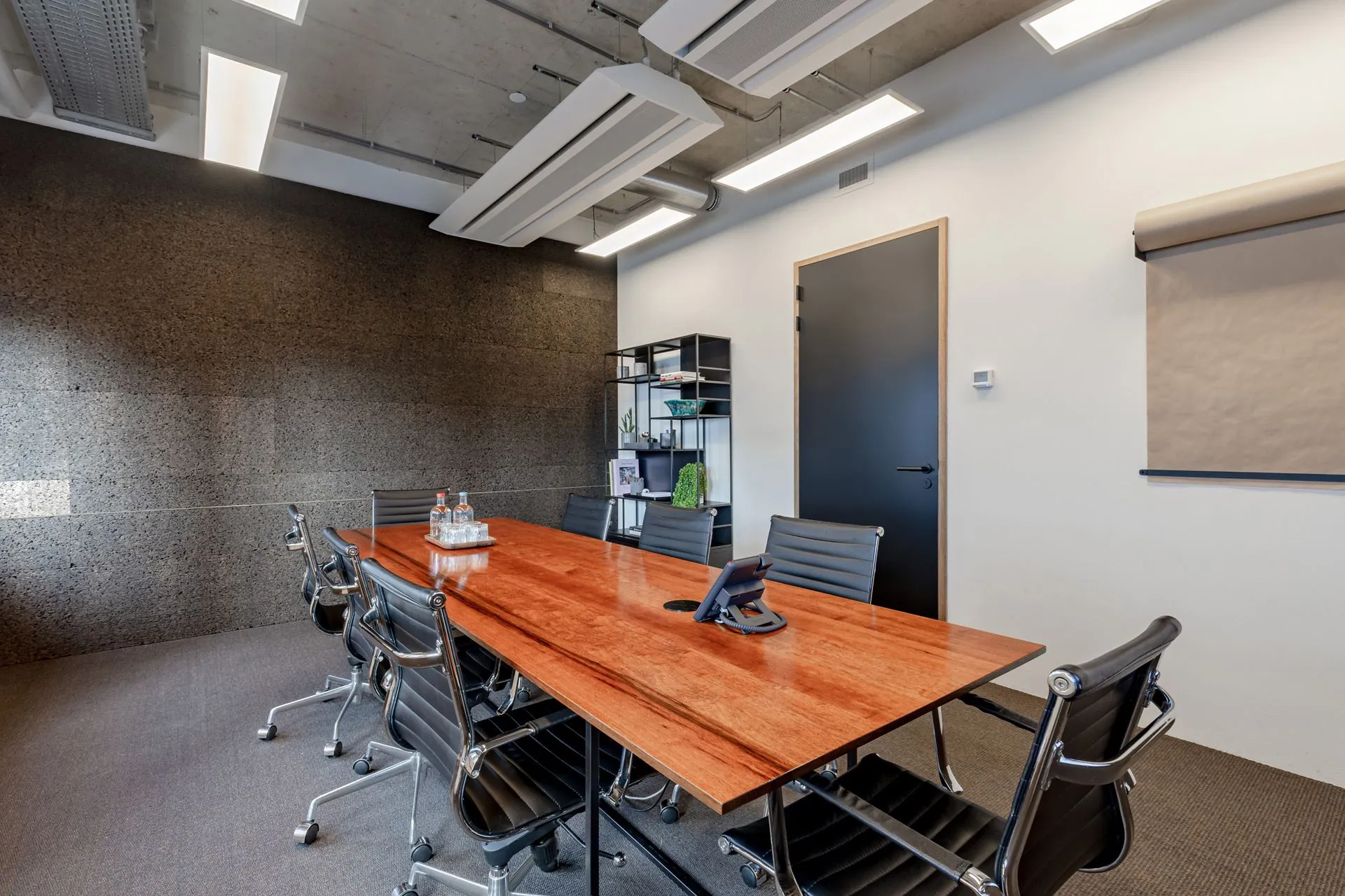 Moderne vergaderruimte aan de Emmasingel 33 met houten tafel, zes stoelen en strakke kantoorinrichting.