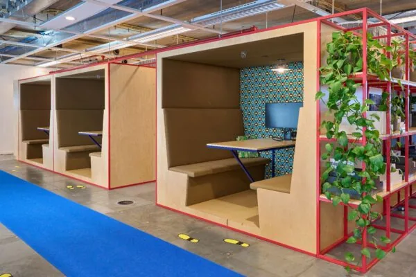 Moderne kantoorruimte aan de Johan Huizingalaan 400 met houten werkpods, kleurrijke details en groene planten.