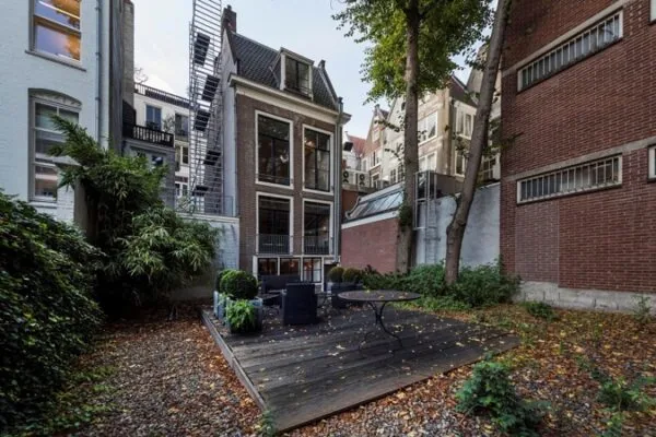Achteraanzicht van een karakteristiek kantoorpand aan de Keizersgracht 467 met houten terras en tuin.