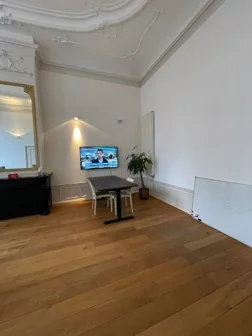 Stijlvolle kantoorruimte aan de Keizersgracht met hoge plafonds, houten vloer en moderne inrichting.