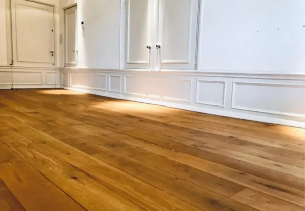 Licht afgewerkte kantoorruimte aan de Keizersgracht 467 met houten vloer en witte lambrisering.