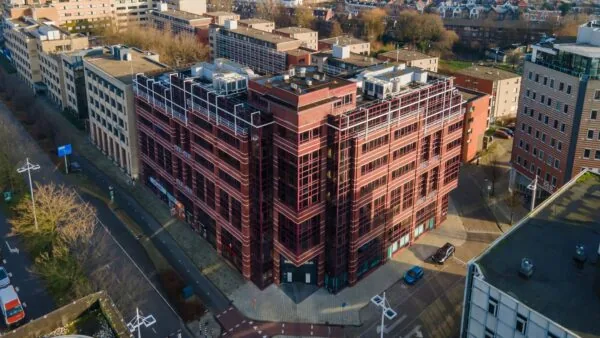 Luchtfoto van het kantoorgebouw aan de Schipholweg 55 in Leiden met omliggende bebouwing.