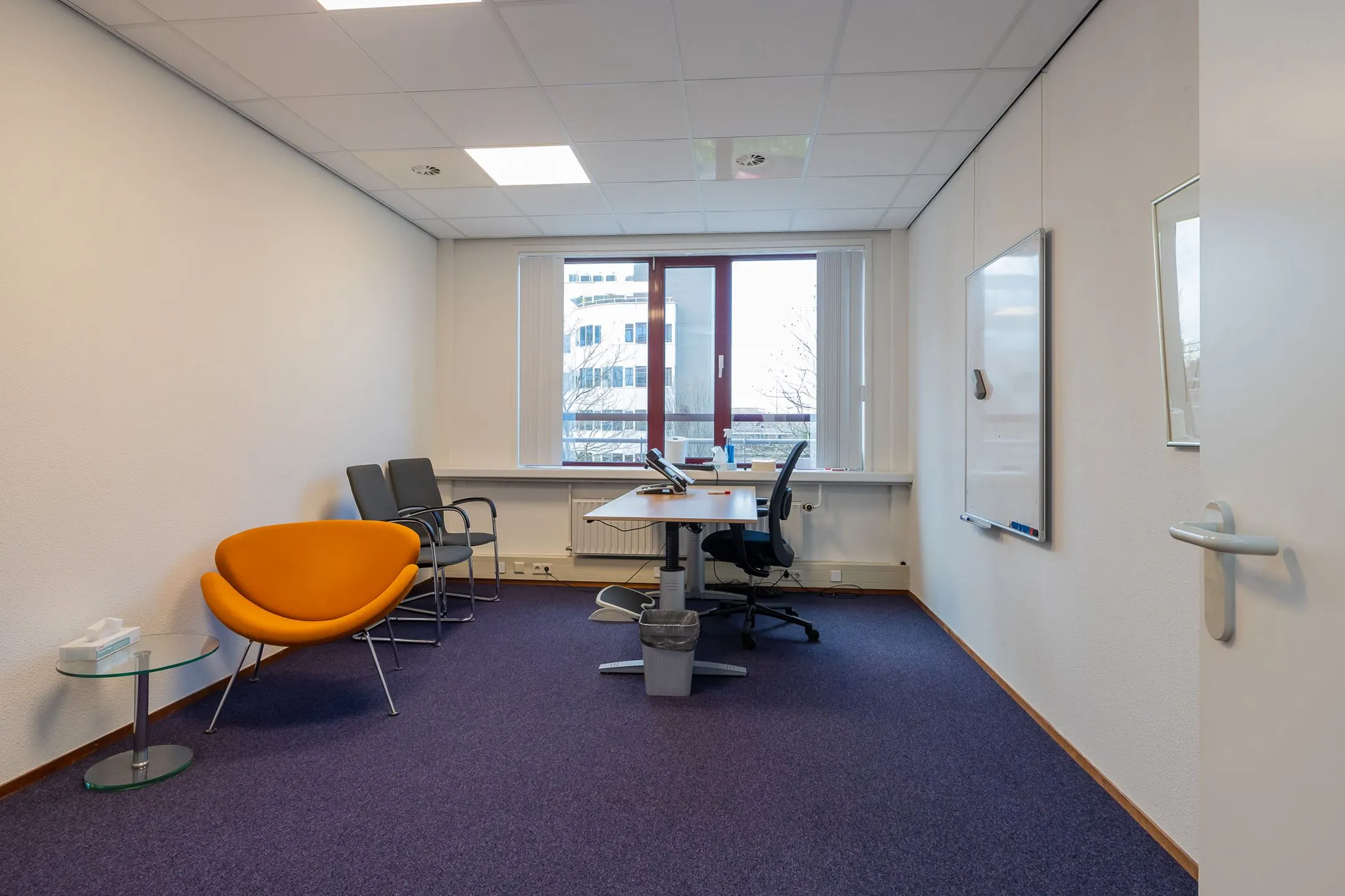 Moderne kantoorruimte met bureau, stoelen en whiteboard aan de Schipholweg 55 in Leiden.