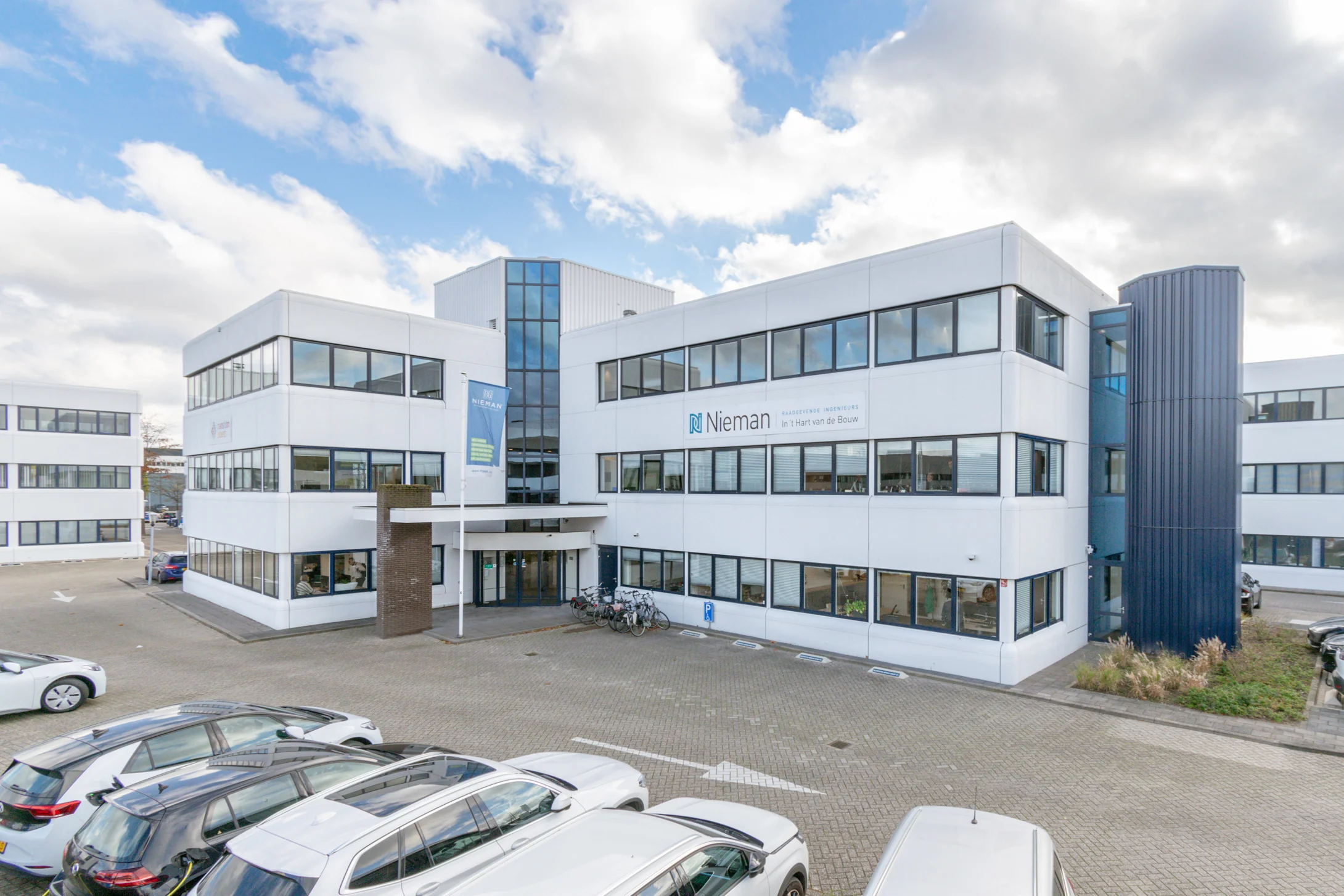 Modern kantoorgebouw aan de Reactorweg 301 met parkeergelegenheid en het logo van Nieman Raadgevende Ingenieurs op de gevel.