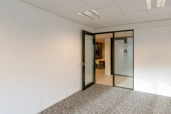 Moderne, lichte kantoorruimte aan de Reactorweg 301 met glazen deur naar een vergaderruimte.