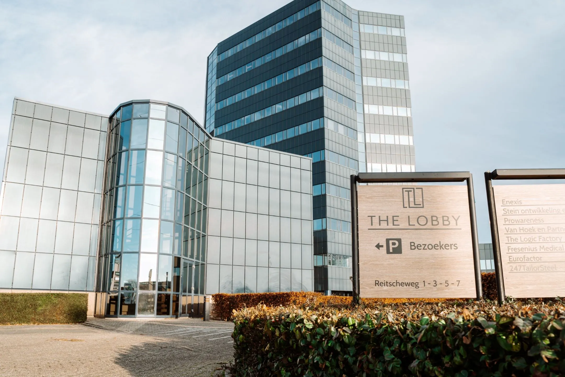 Moderne kantoorgebouwen met bedrijfsnamen en bezoekersbord bij The Lobby aan de Reitscheweg 1-3-5-7.
