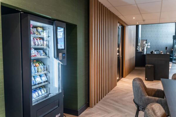 Moderne kantoorruimte aan de Reitscheweg 1-10 met frisdrank- en snackautomaat in een stijlvolle wachtruimte.