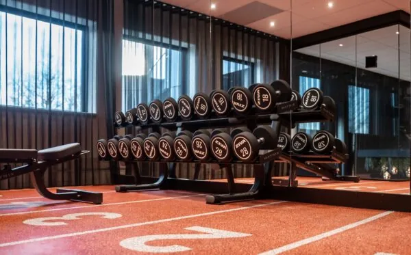 Moderne fitnessruimte in kantoor aan de Reitscheweg 1-4 met halterrek, spiegels en sportvloer.